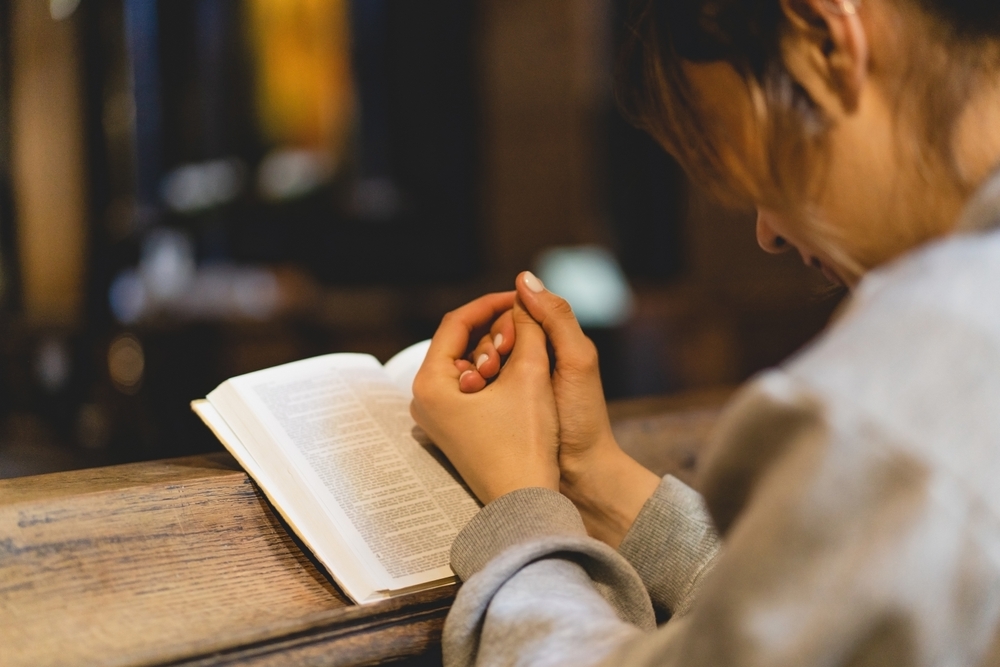 woman reading Bible in quiet reflection rooted in God’s Word